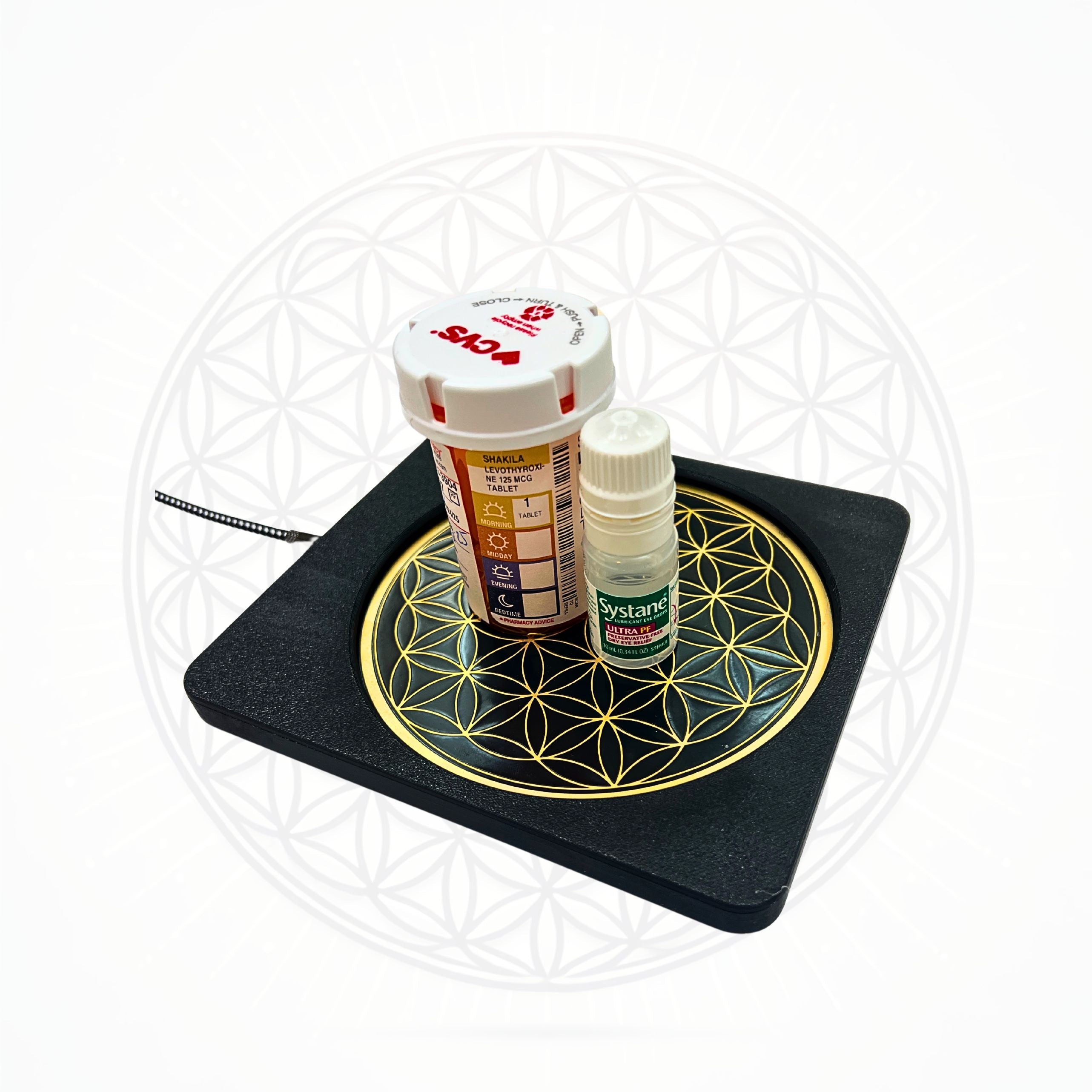 Metatronic Flower of Life Frequency Imprinter by Sacred Ritual Oils with a black base and golden geometric design